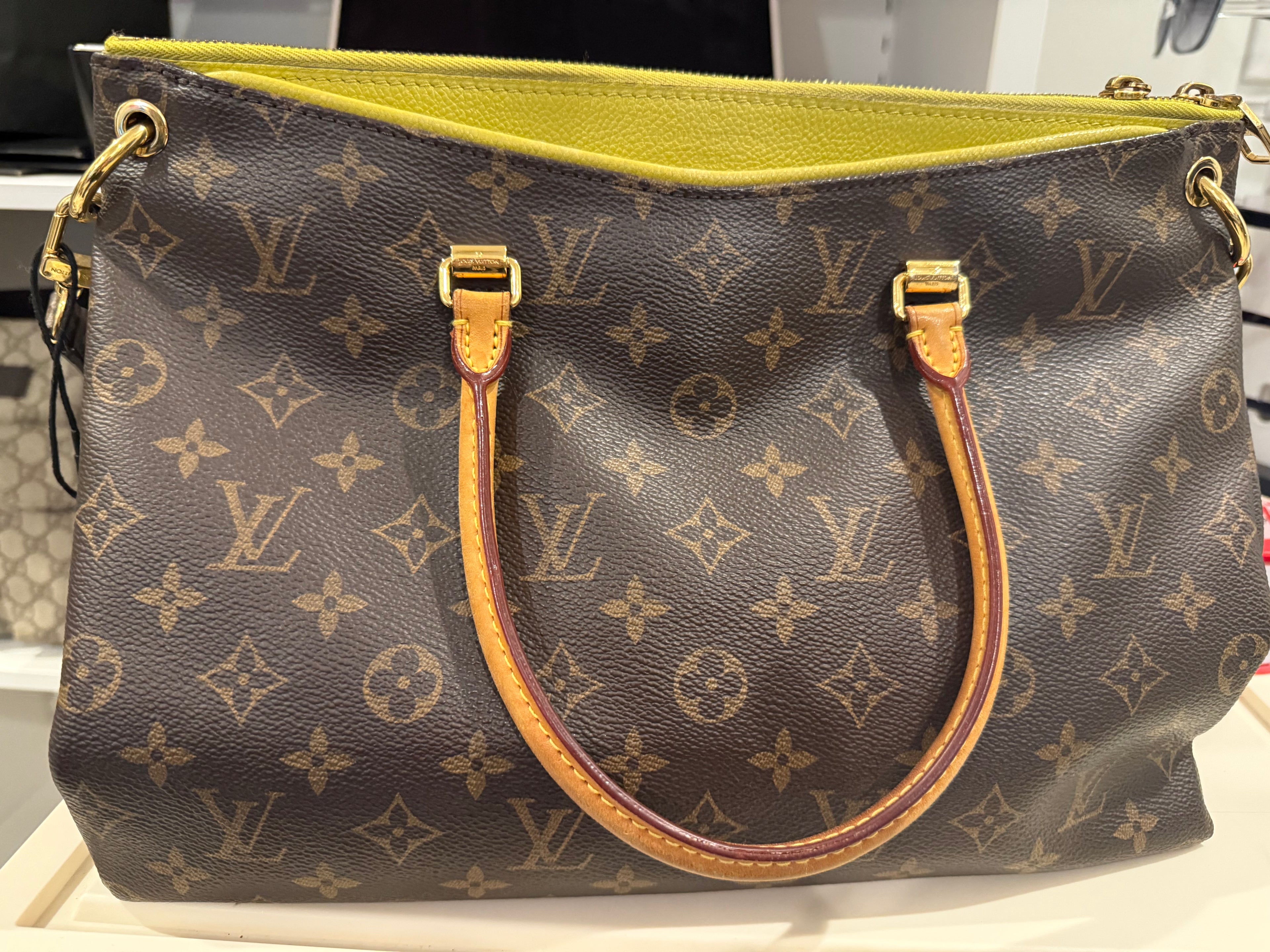 Louis Vuitton Pallas in the Monogram canvas with a yellow/saffron color accent and lining.